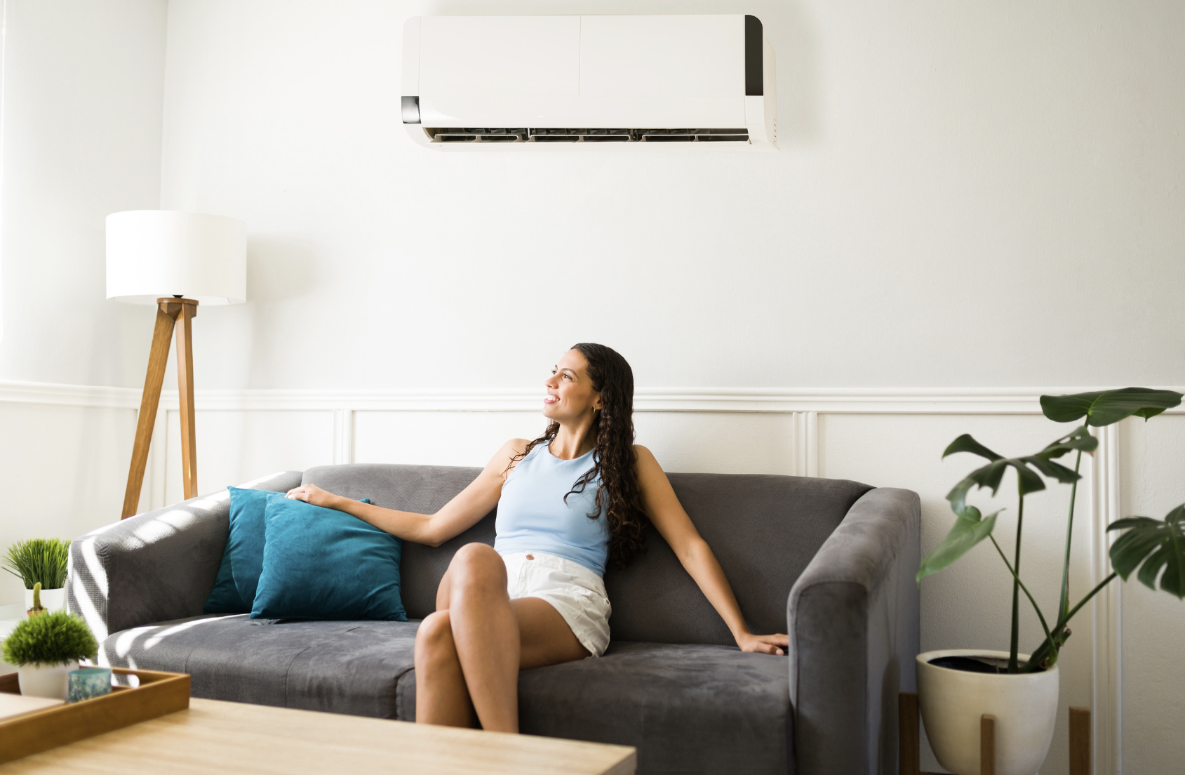Lady on coach below air conditioner reverse cycle split system in Traralgon